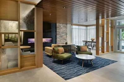 a lobby with chairs and tables and a fireplace at Fairfield by Marriott Inn & Suites Oxford in Oxford