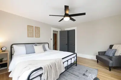 a bedroom with a bed and a ceiling fan at Walk to Highland Square, Sleeps 8 in Akron
