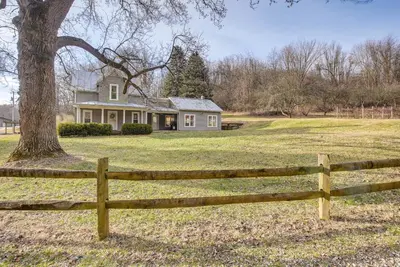 a wooden fence in front of a house with a tree at Patio and Scenic Views Modern Ohio Farmhouse in Bellville