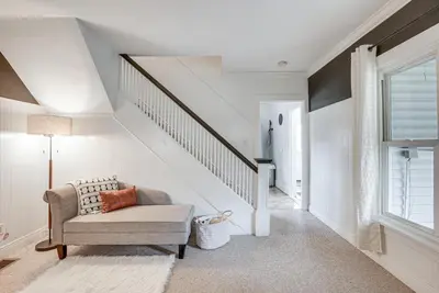 a living room with a chair and a staircase at Patio and Scenic Views Modern Ohio Farmhouse in Bellville
