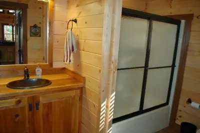 a bathroom with a sink and a mirror at The Secluded Woodbury Cabin, Pond and 42 acres in Warsaw