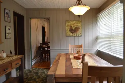 a dining room with a wooden table in a room at Mohican Farmhouse, Pond, and Animals in Perrysville