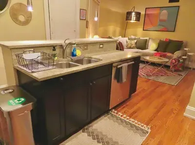 a kitchen with two sinks and a living room at The Nook on Neil Walkable 3BR in Columbus