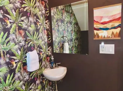 a bathroom with a sink and a flower wallpaper at The Nook on Neil Walkable 3BR in Columbus