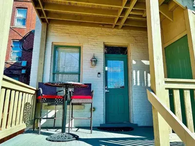 a house with a porch with a table and a door at The Nook on Neil Walkable 3BR in Columbus