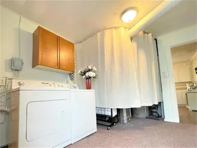 a kitchen with a white curtain and a vase of flowers at High - Family Neighborhood, Pet Friendly in Van Wert