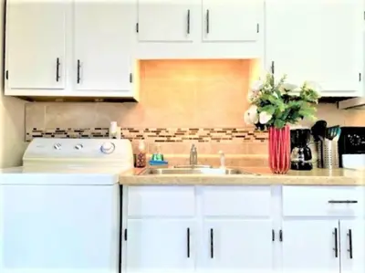 a kitchen with white cabinets and a sink at Pontiac - Secluded Backyard, Pet Friendly in Fort Wayne