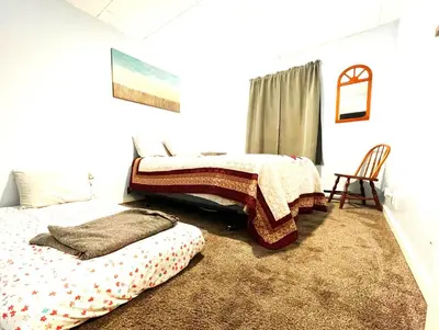 a bedroom with two beds and a chair at Pontiac - Secluded Backyard, Pet Friendly in Fort Wayne