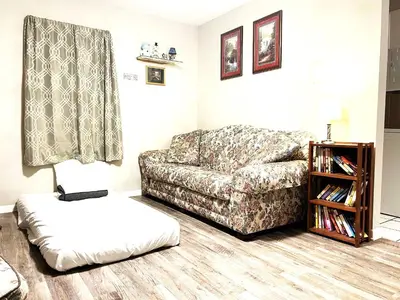 a living room with a couch and a book shelf at Pontiac - Secluded Backyard, Pet Friendly in Fort Wayne
