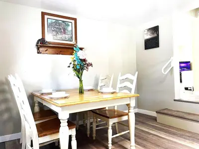 a dining room table with a vase of flowers on it at North - Family Neighborhood, Pet Friendly in Paulding