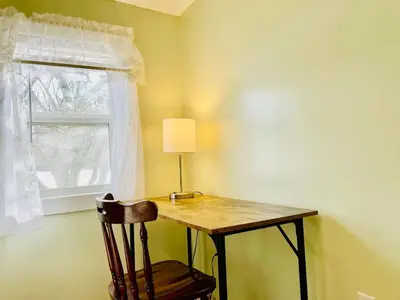 a table with a lamp and a chair next to a window at Rabus GIANT Yard and Parking Nature Shopping in Fort Wayne