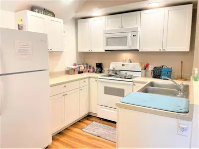 a white kitchen with a sink and a refrigerator at Rabus GIANT Yard and Parking Nature Shopping in Fort Wayne