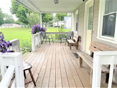 a porch with benches and flowers on a house at Rabus GIANT Yard and Parking Nature Shopping in Fort Wayne