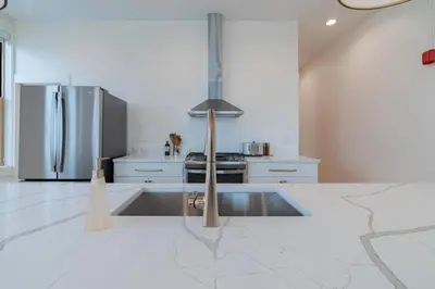 a kitchen with a stainless steel refrigerator and white counters at 'Condo A' Gallery Suite - Downtown Marion in Warren