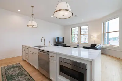 a kitchen with a white counter top and a sink at 'Condo A' Gallery Suite - Downtown Marion in Warren