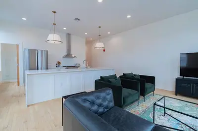 a living room with two couches and a kitchen at 'Condo A' Gallery Suite - Downtown Marion in Warren
