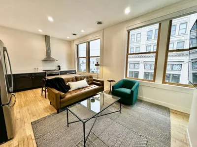 a living room with a couch and a chair at Condo B - Gallery Suite - Downtown Marion in Warren