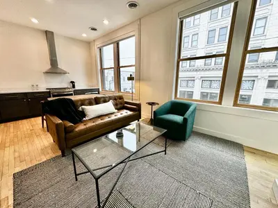 a living room with a couch and a chair at Condo B - Gallery Suite - Downtown Marion in Warren