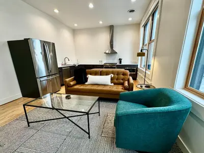 a living room with a couch and a table at Condo B - Gallery Suite - Downtown Marion in Warren