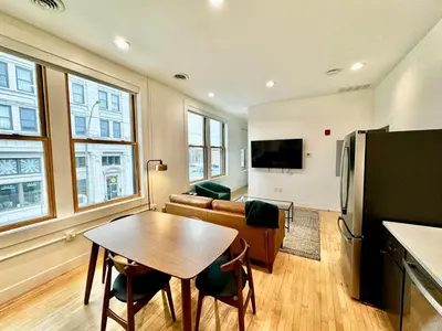 a living room with a table and a couch at Condo B - Gallery Suite - Downtown Marion in Warren