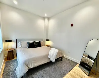 a bedroom with a large bed and a mirror at Condo B - Gallery Suite - Downtown Marion in Warren