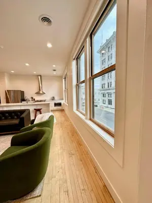 a living room with a green chair and a large window at Condo C - Gallery Suites Downtown Marion in Warren