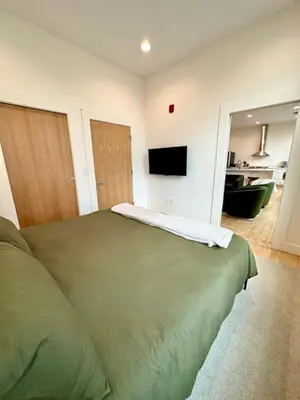 a bedroom with a bed and a flat screen tv at Condo C - Gallery Suites Downtown Marion in Warren