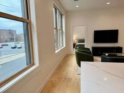 a living room with a couch and a tv and a window at Condo C - Gallery Suites Downtown Marion in Warren