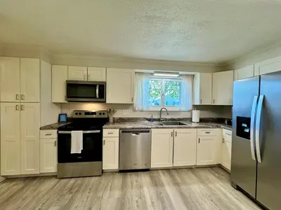 a kitchen with white cabinets and a blue refrigerator at Idle Springs in Marion