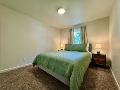 a bedroom with a green bed and a window at Idle Springs in Marion
