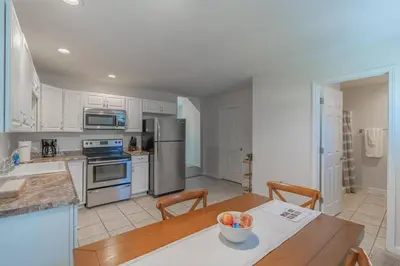 a kitchen with stainless steel appliances and a wooden table at Loft on Landess in Marion