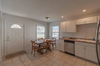a kitchen with a table and chairs and a kitchen with white cabinets at Loft on Landess in Marion
