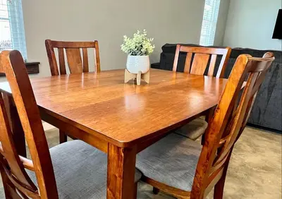 a wooden table with a vase of flowers on it at Posh Pad in Marion