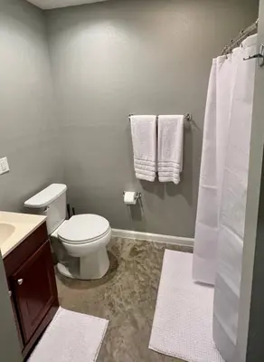 a bathroom with a toilet and a sink with towels at Posh Pad in Marion