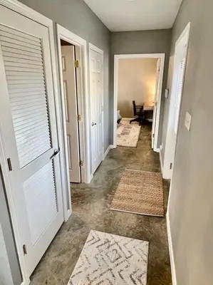 a hallway with two white doors and two rugs at Posh Pad in Marion