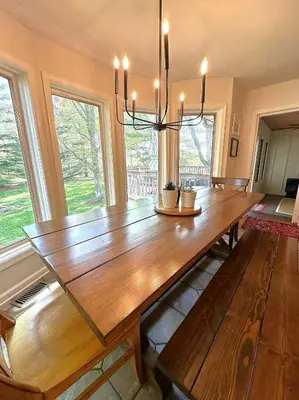 a large wooden table in a room with windows at Four Oaks Ranch in Marion