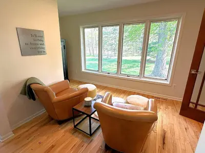 a living room with two chairs and a large window at Four Oaks Ranch in Marion