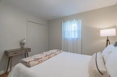 a white bedroom with a white bed and a window at The Lime House in Gas City