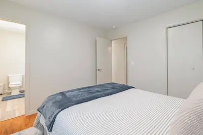 a white bedroom with a bed and a window at The Lime House in Gas City