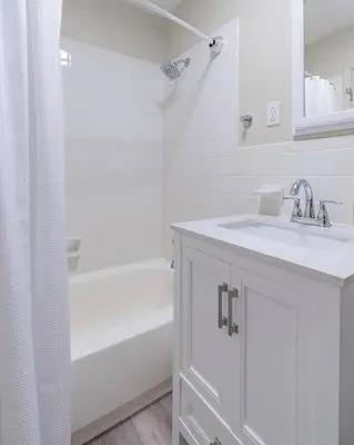 a white bathroom with a sink and a bath tub at The Lime House in Gas City