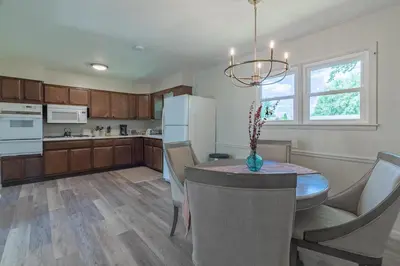 a kitchen with a table and chairs and a refrigerator at The Lime House in Gas City