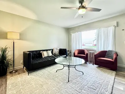 a living room with a black couch and a glass table at The Lime House in Gas City