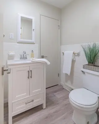 a white bathroom with a toilet and a sink at The Lime House in Gas City