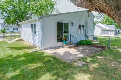 a small white shed with a porch in a yard at The Luxe in Marion