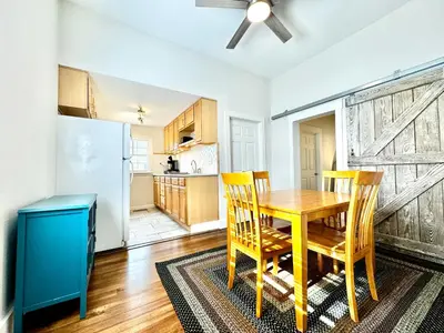 a kitchen and dining room with a wooden table and chairs at Trojan Hideaway on First Street in Gas City