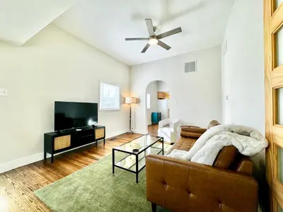 a living room with a couch and a flat screen tv at Trojan Hideaway on First Street in Gas City