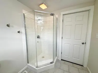 a shower with a glass door in a bathroom at Trojan Hideaway on First Street in Gas City
