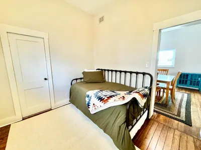 a small bedroom with a bed and a table at Trojan Hideaway on First Street in Gas City