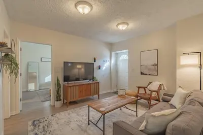 a living room with a couch and a flat screen tv at University Suite 