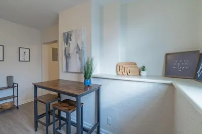 a room with a counter and a table with a plant on it at University Suite 